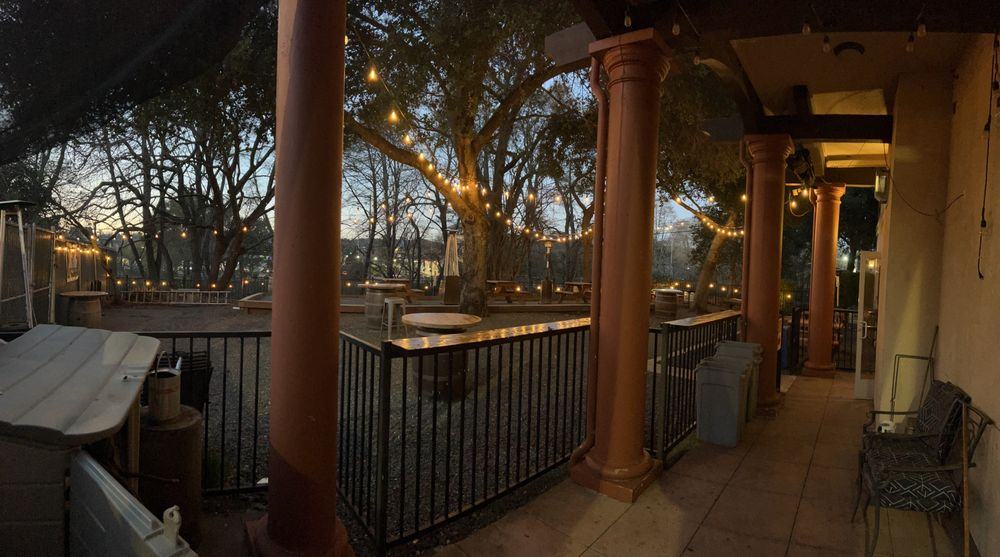 The covered walkway and string lights over the patio at dusk